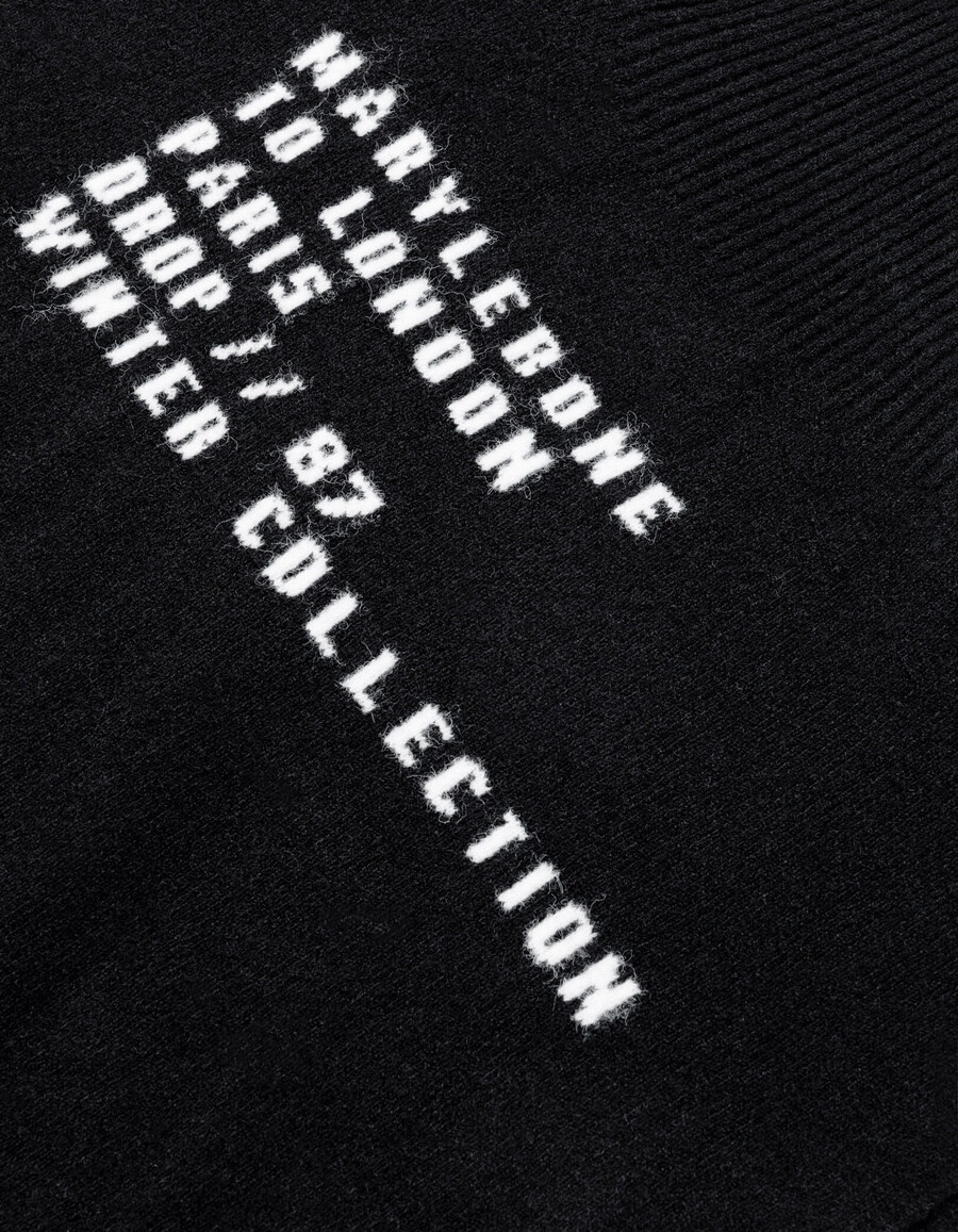 schwarzer damen-poncho aus jacquard-strick mit slogan