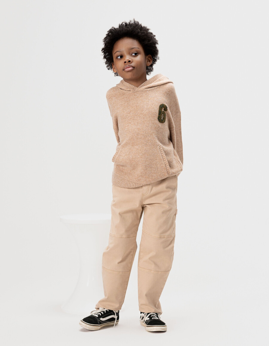 beige melierte strickkapuze für jungen mit nummernaufnäher