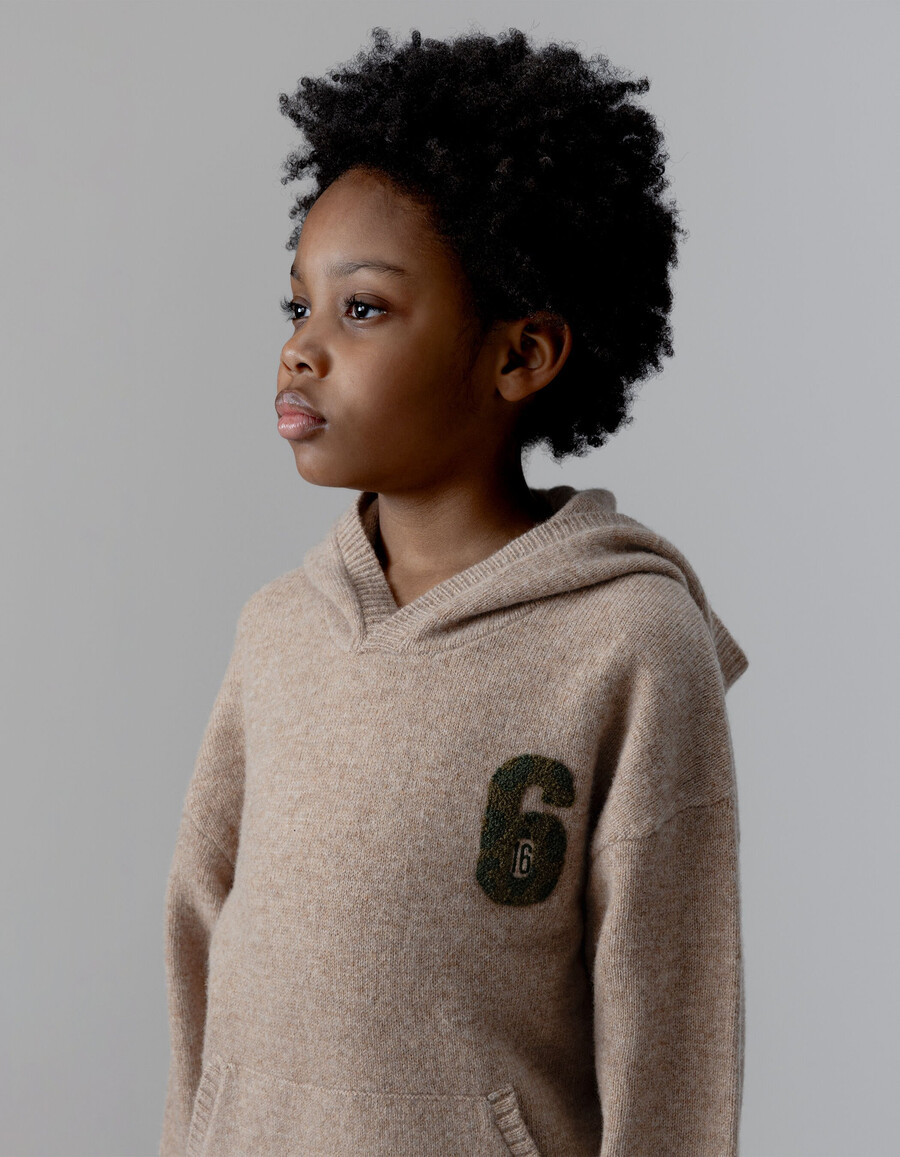 beige melierte strickkapuze für jungen mit nummernaufnäher