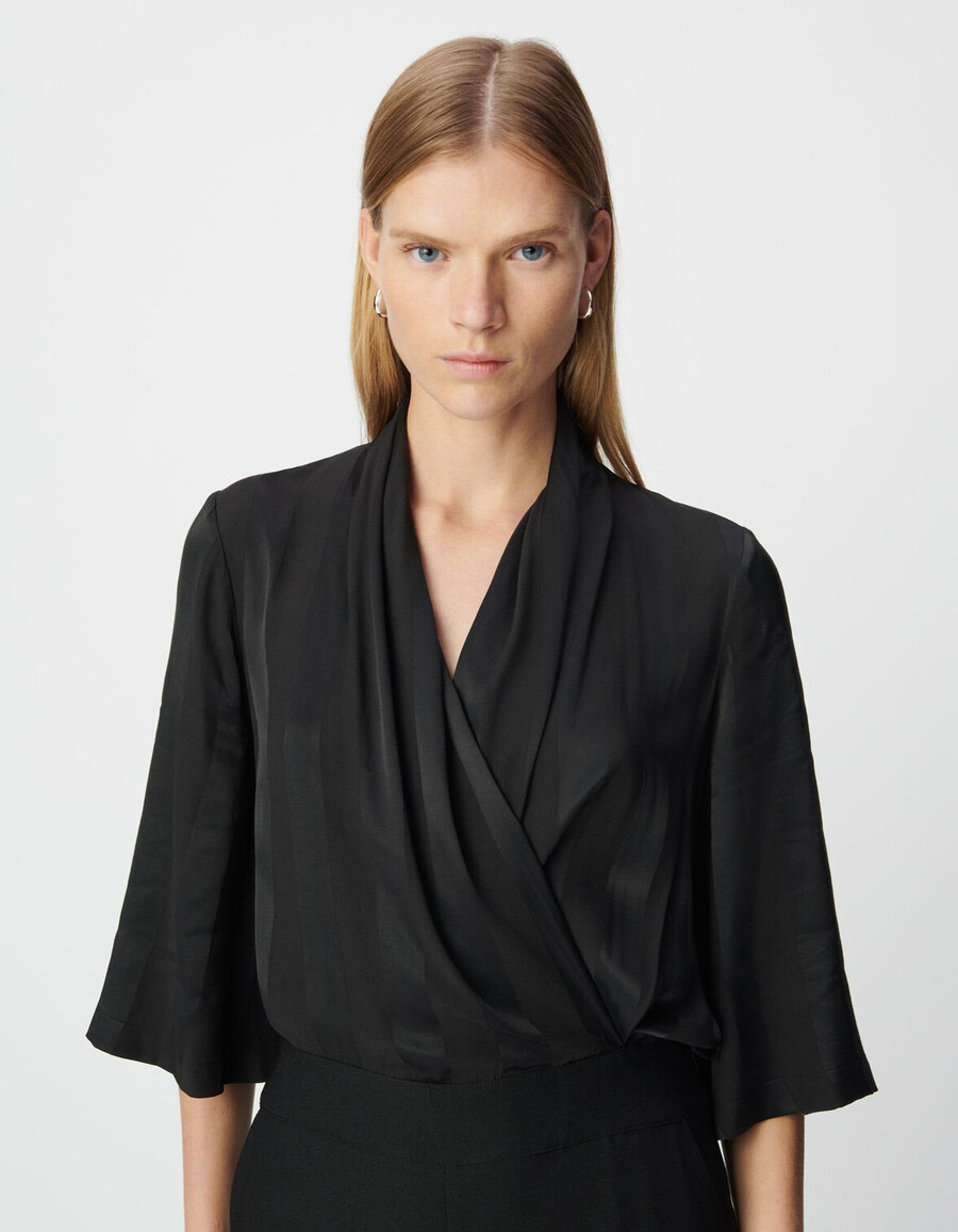 schwarzer damen-jumpsuit aus materialmix mit fließendem oberteil