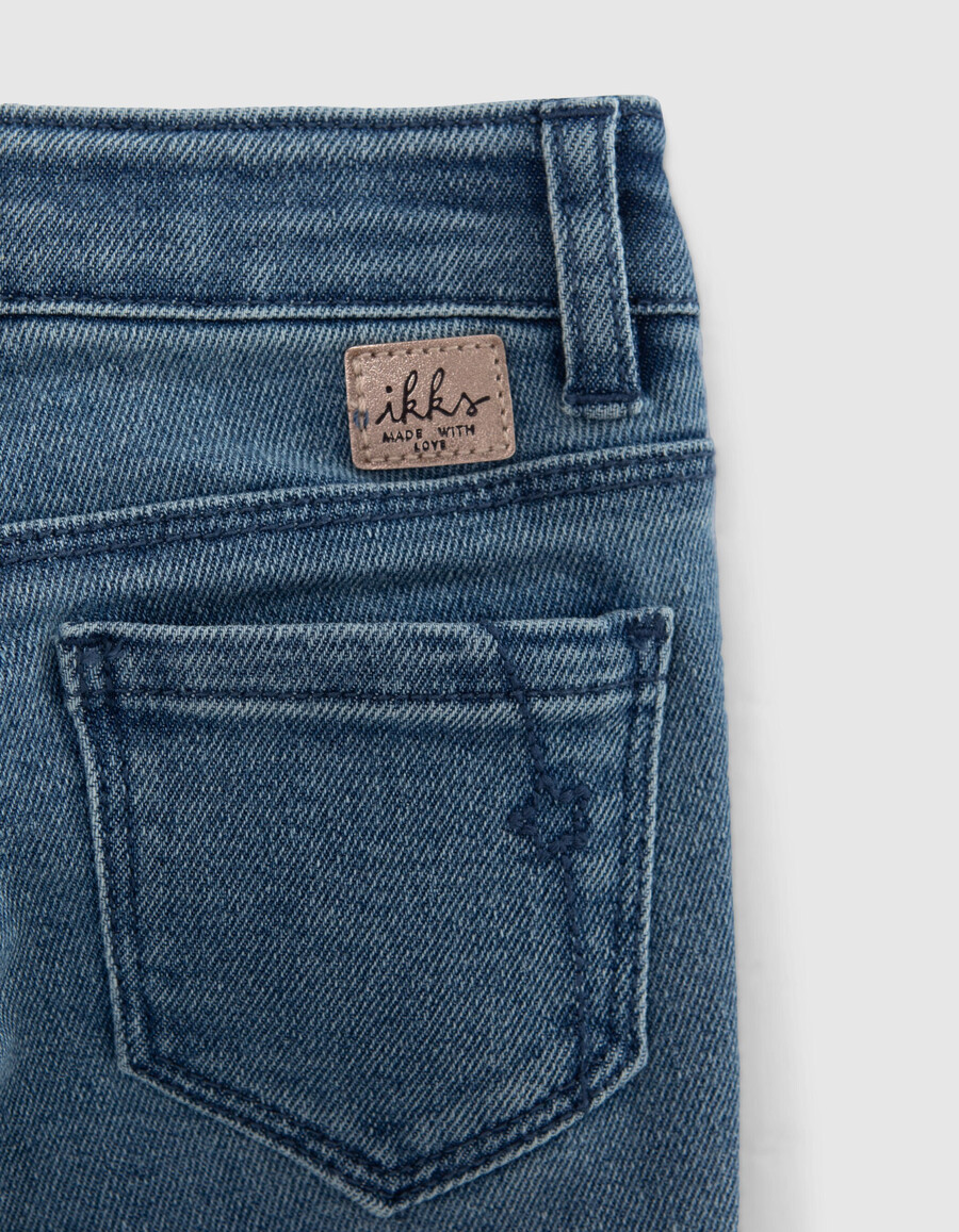 mädchen-jeans mit blauem schlag und aufgesetzten taschen