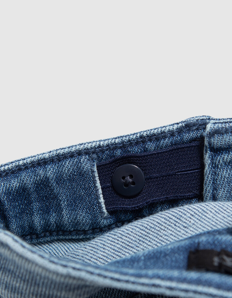 mädchen-jeans mit blauem schlag und aufgesetzten taschen