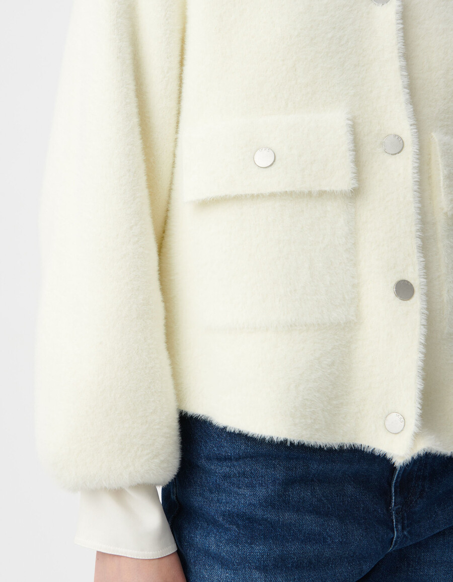 weißer flauschiger damen-strickcardigan mit aufgesetzten druckknopftaschen